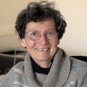 Woman with glasses smiling at the screen