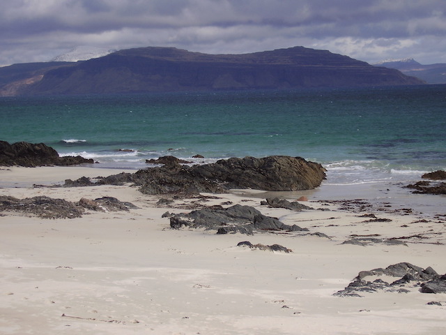 A view over the Sound of Iona. The sea is green, mountains in the background are blue.