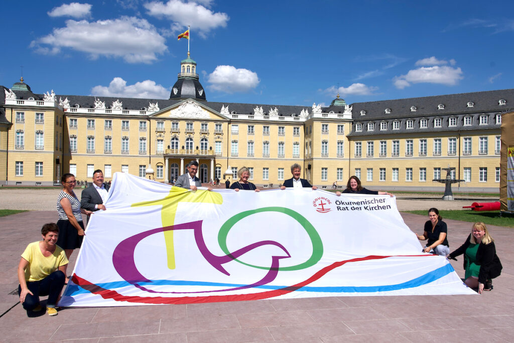 Attendees at the WCC Assembly hold the conference flag in front of Karlsruhe palace