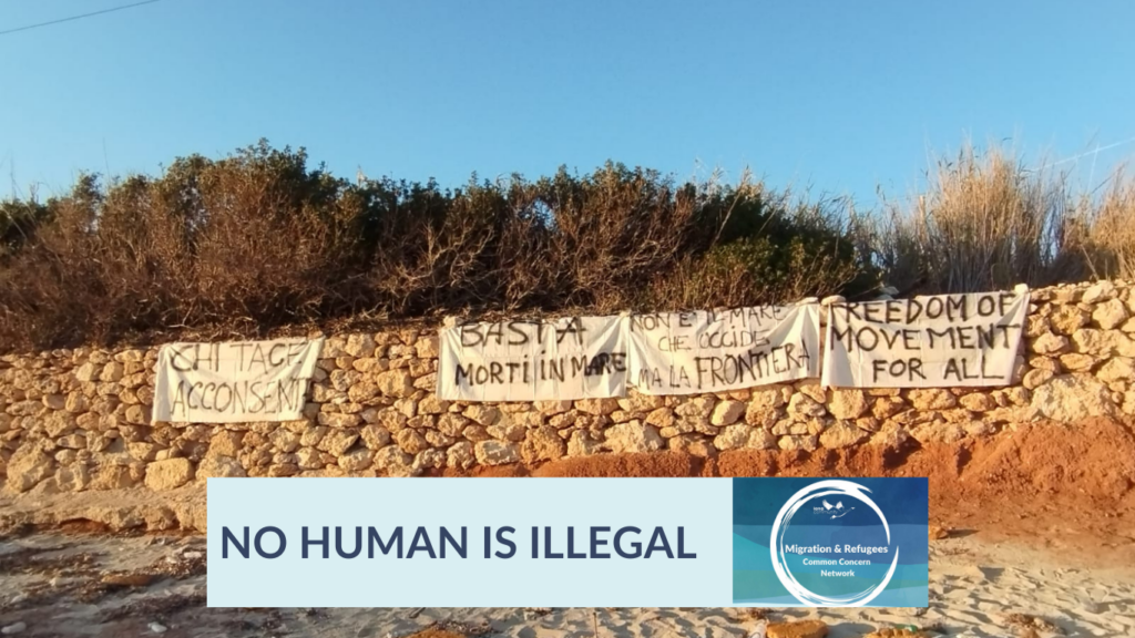 Banners, hung from a stone wall, read in Italian: "Those who keep silent consent", "No more deaths at sea", "It's not the sea but the border which kills"