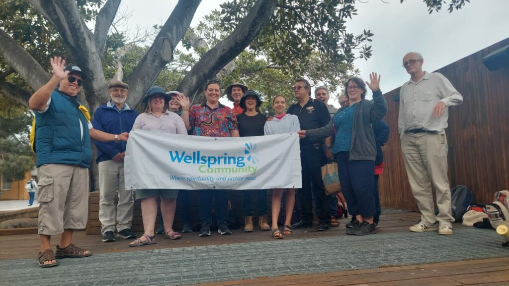 Full group photo holding Wellspring Community banner