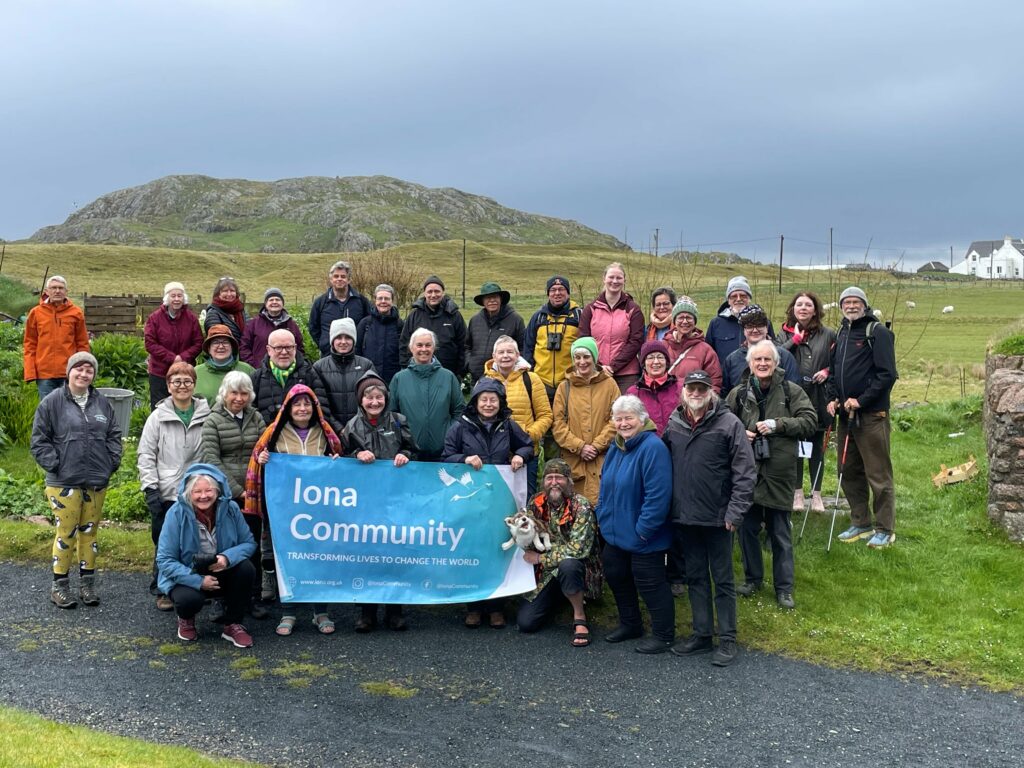Group of people standing on Iona on a grey day.