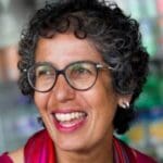 Woman with black curly hair and glasses
