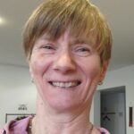 Woman with short brown hair smiling at the camera.