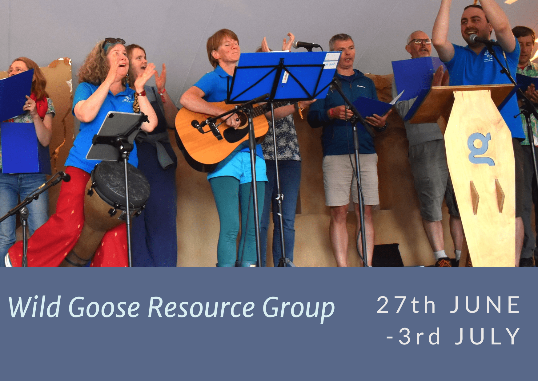 Wild Goose Resource Group on stage leading singing at Greenbelt.