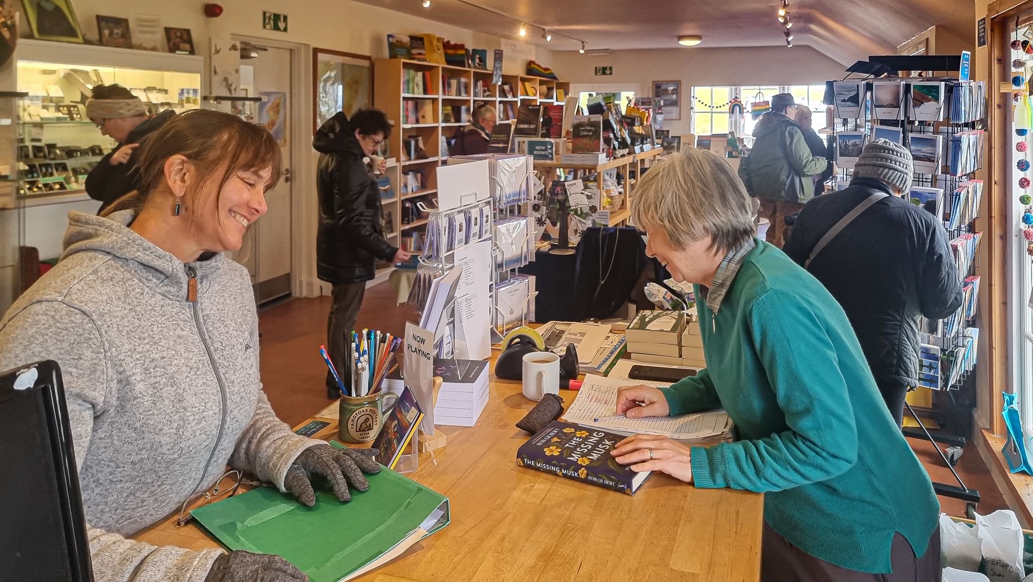 Two women greet each other in a bookshop