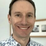 Man smiling with a floral shirt on.