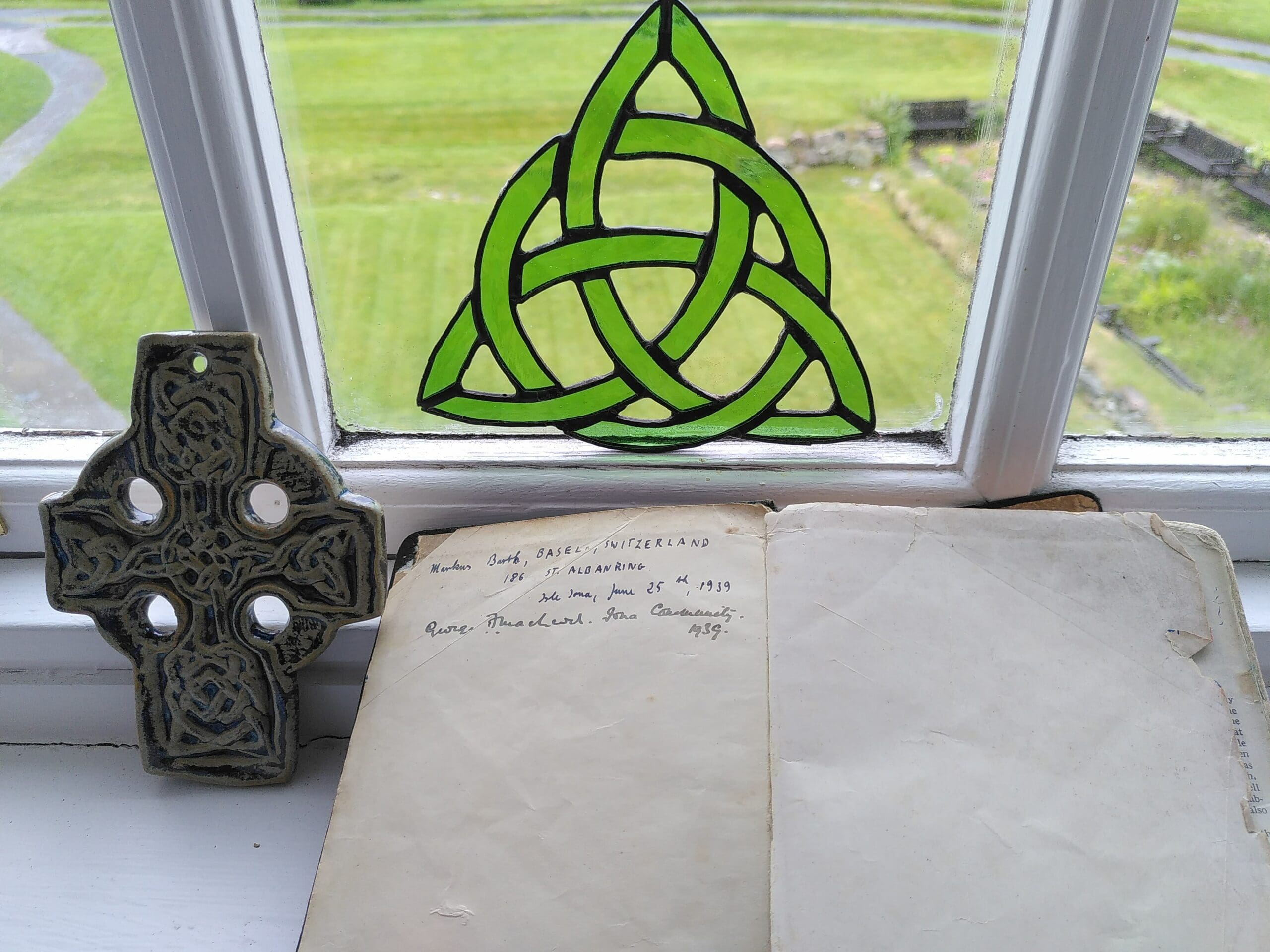 A Celtic knot and cross with some old writing in a notebook