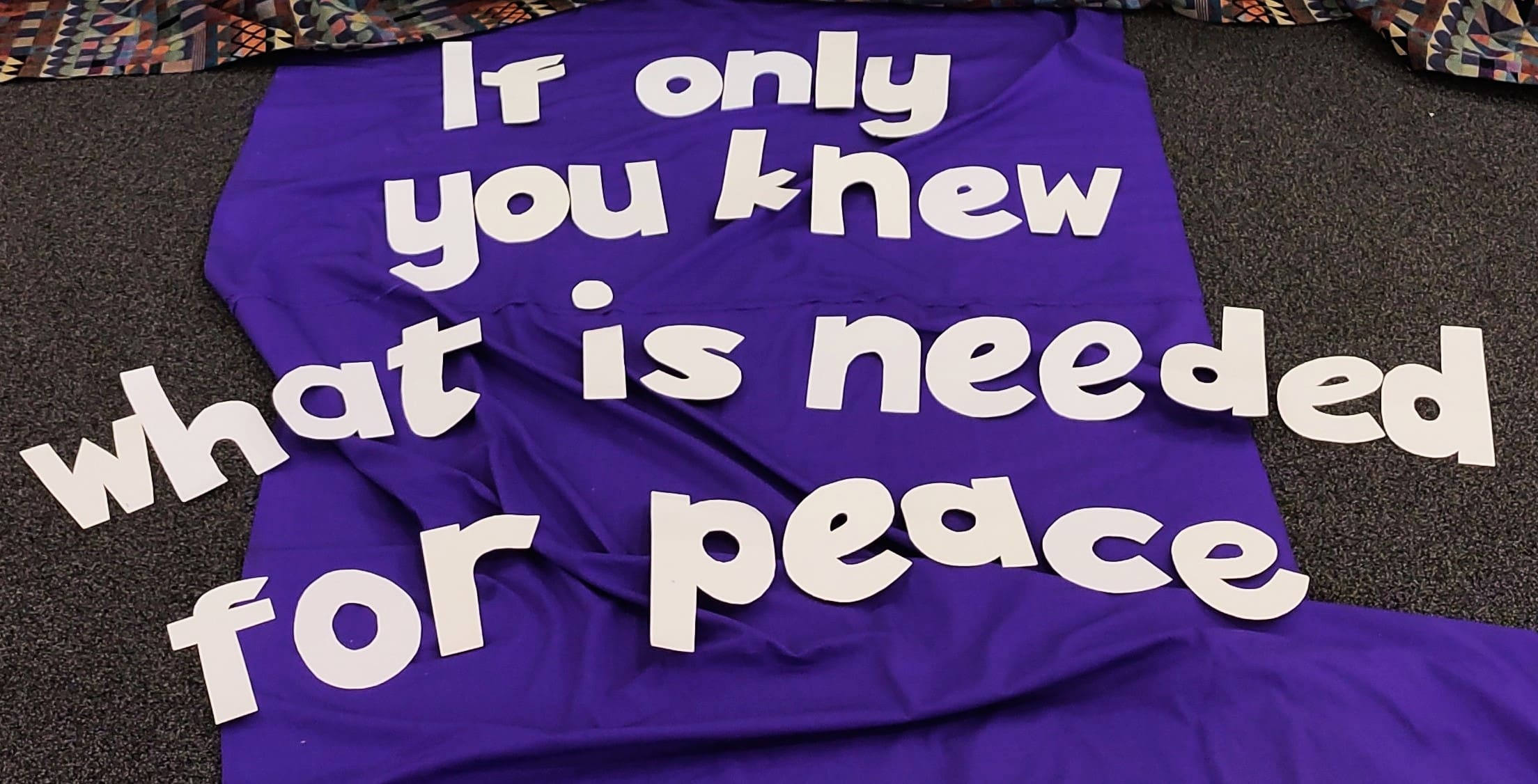 If only you knew what is needed for peace lettering set against purple fabric